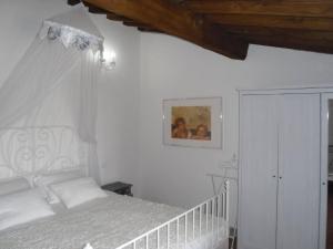 ein Schlafzimmer mit einem weißen Bett mit Baldachin in der Unterkunft Holiday home Garetto in Chianni