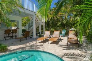 a patio with chairs and a swimming pool at Footprints in the Sand managed by Beach Retreats in Holmes Beach