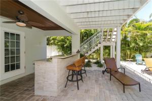a patio with chairs and a bar on a house at Footprints in the Sand managed by Beach Retreats in Holmes Beach
