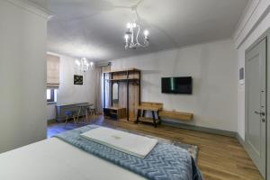 Schlafzimmer mit einem Bett und einem Flachbild-TV in der Unterkunft Álbero Hotel in Pérama