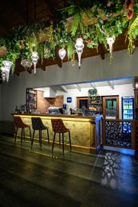 un bar en una habitación con sillas y luces en Álbero Hotel, en Pérama