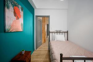a bedroom with a bed and a green wall at Central Art Maisonette by Estia in Heraklio Town