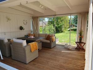 eine abgeschirmte Veranda mit einem Sofa und einem Tisch in der Unterkunft Drag 171 Villa Sjödal in Drag