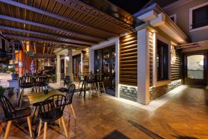 un restaurant avec des tables et des chaises sur une terrasse dans l'établissement Álbero Hotel, à Pérama