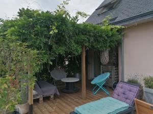 a pergola with a table and chairs on a deck at Tous à l'ouest in Combrit