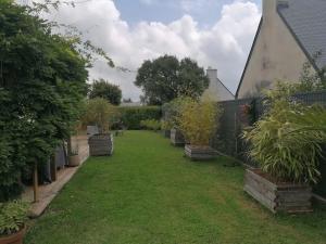 a garden with potted plants and a fence at Tous à l'ouest in Combrit