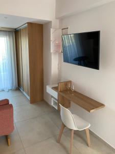 a room with a desk and a television on a wall at ANAX SUITE in Pera Gyalos