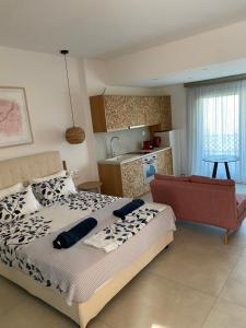 sypialnia z dużym łóżkiem i kuchnią w obiekcie ANAX SUITE w mieście Pera Gyalos
