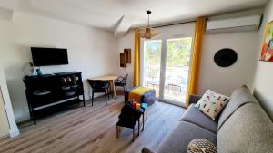 een woonkamer met een bank, een tv en een tafel bij Fiori di Cala Rossa résidence hôtelière in Lecci