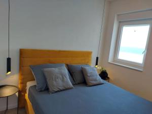 a bedroom with a blue bed with a window at Penthouse Petra with hot tub in Kali
