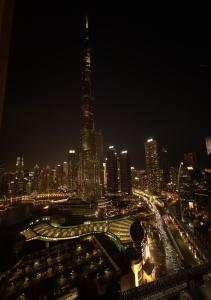 eine Skyline der Stadt in der Nacht mit einem hohen Gebäude in der Unterkunft Luxe - Fashion Avenue Dubai Mall - Formerly Address Dubai Mall in Dubai