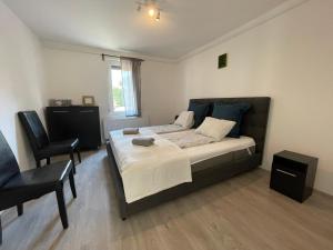 a bedroom with a large bed and a chair at New Beachapartman in Siófok