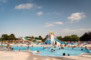 un grupo de personas en una piscina en un parque acuático en Camping les dunes de Contis 3* grand emplacement ombragé et calme, en Saint-Julien-en-Born