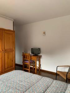 Casa planominguero في تاوول: غرفة نوم بسرير ومكتب مع تلفزيون