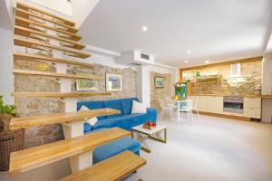 een woonkamer met een blauwe bank en een keuken bij Villa Sokol with tennis court, heating pool, gym and sauna in Sokoli