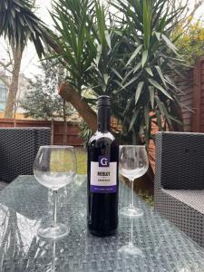 una botella de vino y dos copas de vino en una mesa en Garden Flat, en Londres