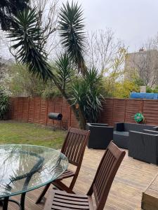 a patio with two chairs and a glass table at Garden Flat in London
