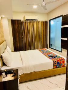 a bedroom with a large bed and a window at Hotel Embassy Park - BKC Mumbai in Mumbai