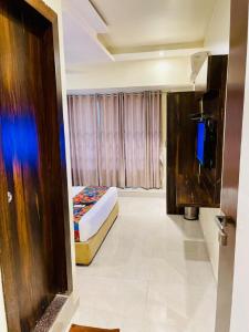 a hotel room with a bed and a window at Hotel Embassy Park - BKC Mumbai in Mumbai