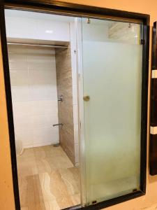 a glass door in a bathroom with a shower at Hotel Embassy Park - BKC Mumbai in Mumbai