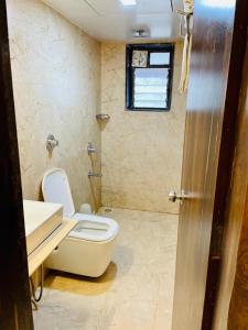 Hotel Embassy Park - BKC Mumbai في مومباي: حمام مع مرحاض ومغسلة