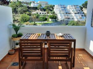 Spirit of Mojacar Playa Resort 'Casa Juana' في موجاكار: طاولة وكراسي على شرفة مطلة