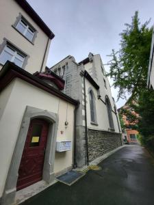 ein Gebäude mit einer roten Tür neben einer Straße in der Unterkunft Ferienwohnungen zu St. Johann in Konstanz
