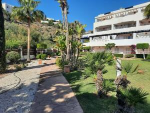 a walkway in front of a building with palm trees at Spirit of Mojacar Playa Resort 'Casa Juana' in Mojácar