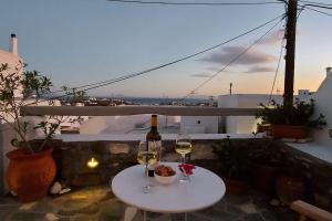 a table with two glasses of wine and a bottle at L' Atelier, Marpissa Paros in Márpissa