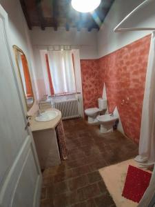 La salle de bains est pourvue d'un lavabo et de toilettes. dans l'établissement Agriturismo Paneolio, à Villa Collemandina