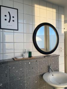 La salle de bains est pourvue d'un miroir et d'un lavabo. dans l'établissement The Penthouse Suite Apartment, à Stierstadt