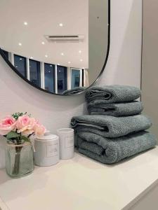 a bathroom with a pile of towels and a mirror at The Penthouse Suite Apartment in Stierstadt