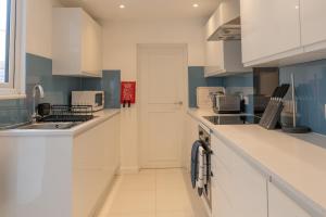cocina blanca con fregadero y encimera en Church House - 2 Bed-Sleeps 4-TJS21CH, en Ilfracombe