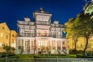 ein großes weißes Gebäude mit einem Uhrturm oben in der Unterkunft Villa Baltik in Binz