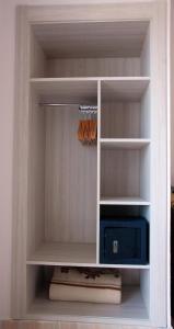 a closet with a white shelf with a blue appliance at Hostal Mar y Huerta in Es Cana