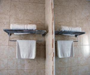 a bathroom with towels on racks in a shower at Hostal Mar y Huerta in Es Cana