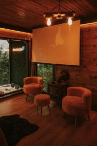a living room with two chairs and a projection screen at Pavri suit bungalov in Ardeşen