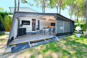 awning of a camper with a table in a backyard at Luxury Caravan at Union Lido in Cavallino-Treporti