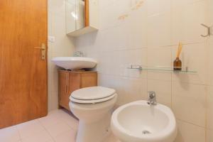 een witte badkamer met een toilet en een wastafel bij Appartamento Per Due by HelloElba in Portoferraio