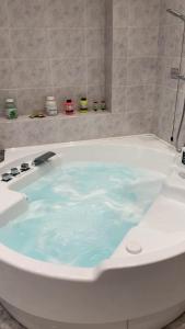 e bagno con vasca riempita di acqua blu. di B & B Villa Fiorella a Termoli