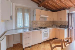 een keuken met een wastafel en een fornuis bij Appartamento Per Due by HelloElba in Portoferraio
