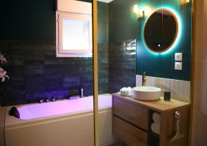 a bathroom with a tub and a sink and a mirror at L'Eden Chic - Balneo - Jardin - Parking gratuit in Arras