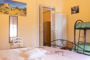 um quarto com uma cama, uma cadeira e uma janela em casa vacanza Noctua em Galatina