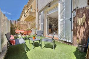 un patio con sillas y una mesa en el césped en Residence Provence plage, en La Ciotat