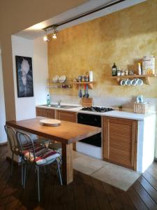 una cucina con tavolo in legno e piano cottura di Casa Beatrice a Castiglioncello