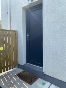a blue door on a building with a wooden fence at Beautiful one bedroom Apartment In Galway City in Galway