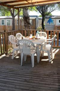 a white table and chairs on a wooden deck at Mobilhome «La mouette rieuse» * 6 personnes *Climatisatisé *2 Chambres in Sigean