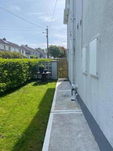 高威的住宿－Beautiful one bedroom Apartment In Galway City，一条人行道,旁边是一座白色的建筑,有院子