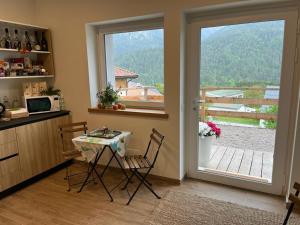 een keuken met een tafel en stoelen en een raam bij Alle Arce in Domegge di Cadore