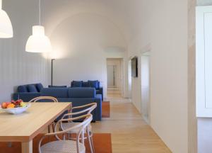 a living room with a table and a blue couch at Montebelo Mosteiro de Alcobaça Historic Hotel in Alcobaça